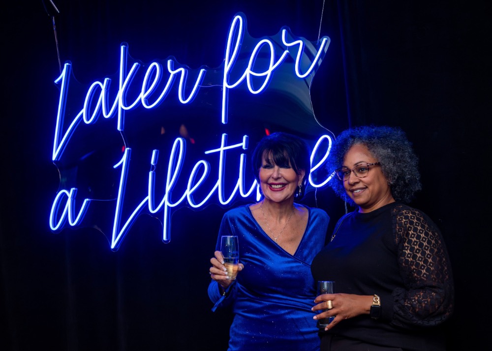 Woman and President Mantella in front of neon sign